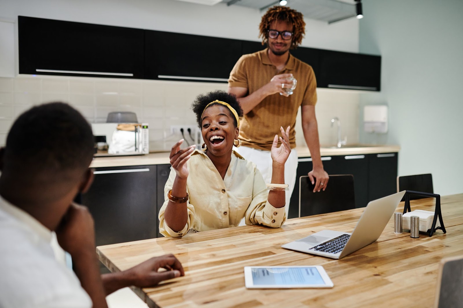 Photo of three employees having a conversation in a break room