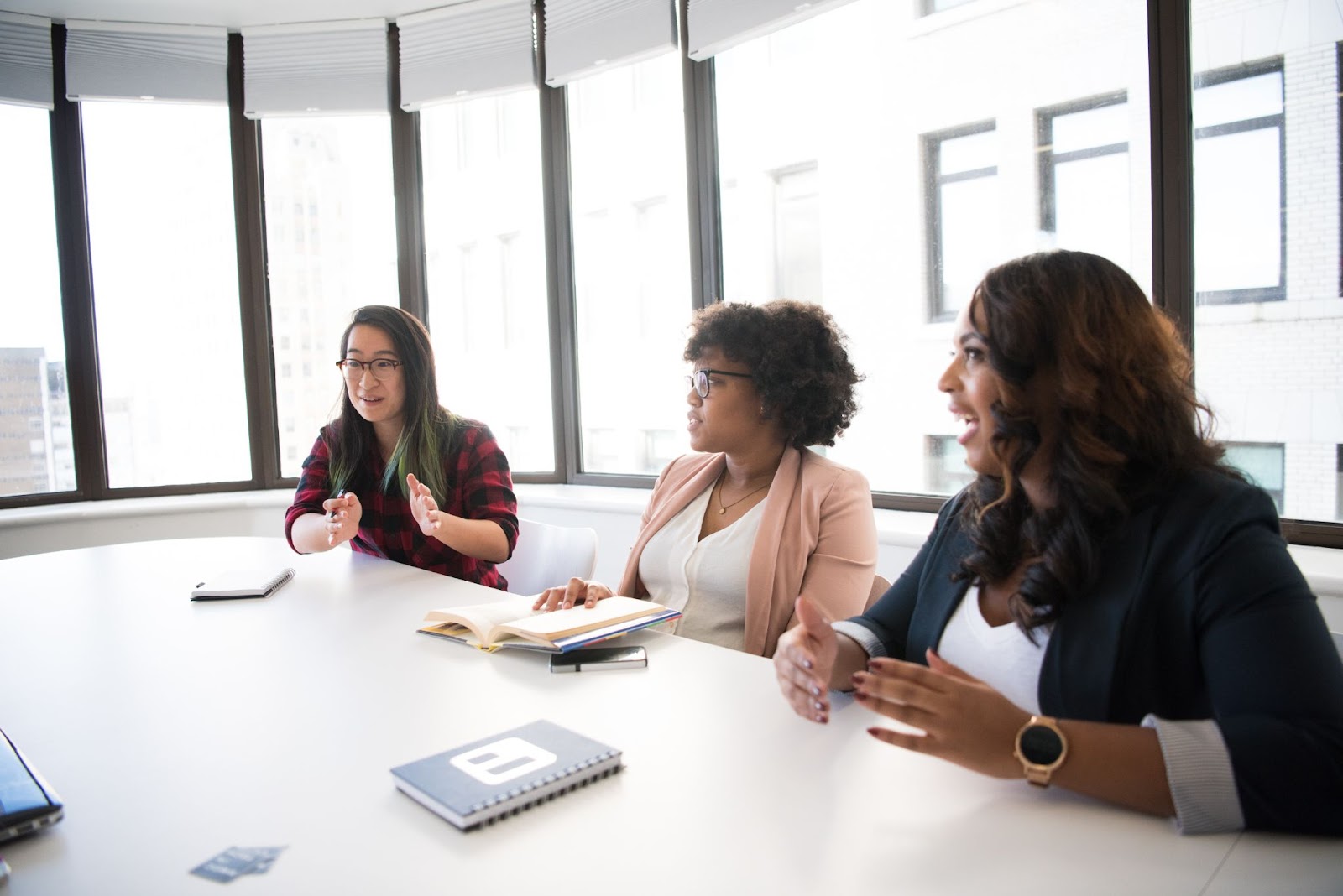 Photo of three professionals talking around a table