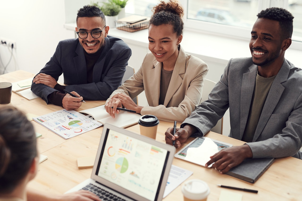 Photo of happy-looking employees around a table.