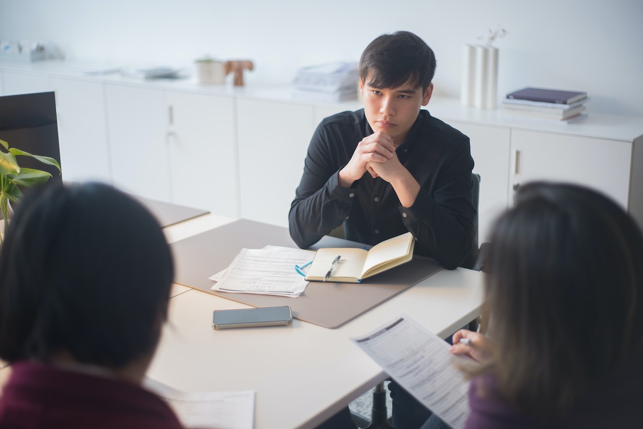 A photo of two managers and their report in a promotion meeting.