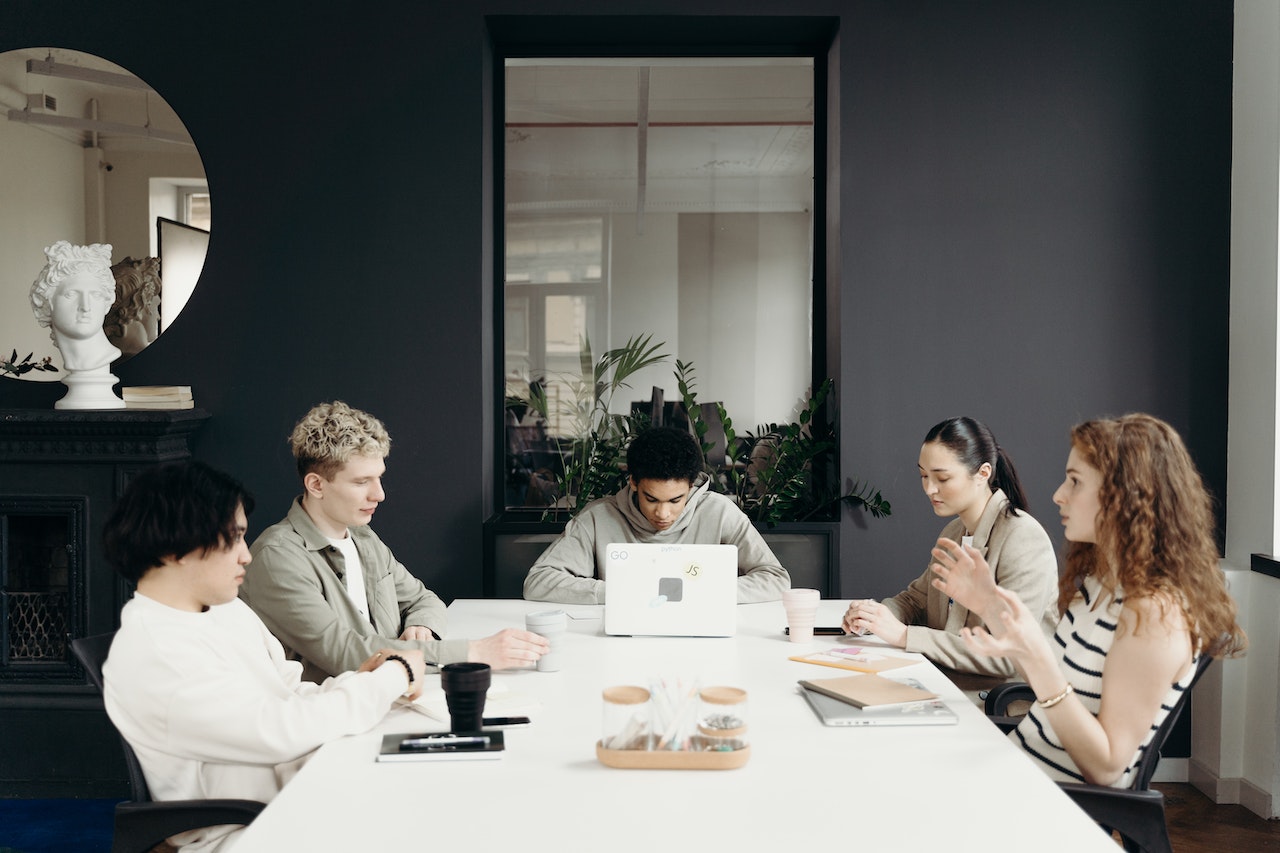 Photo of five employees in a meeting.