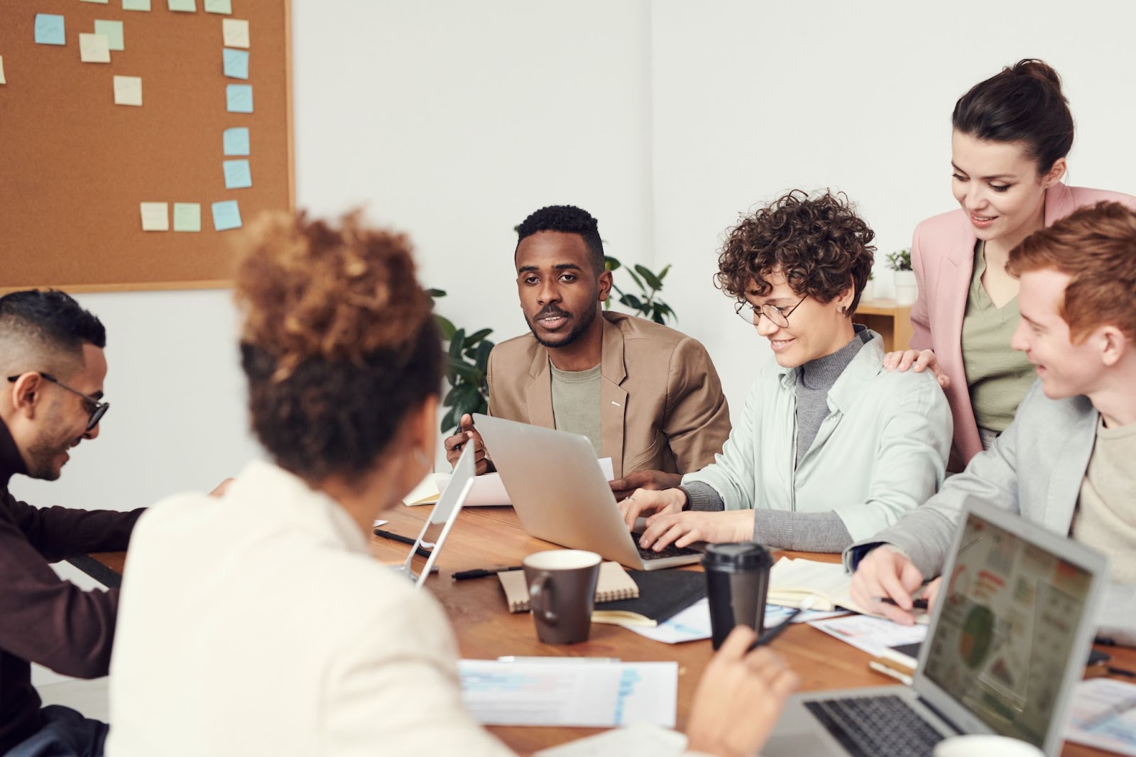 A photo of employees in a meeting, sitting around a table.