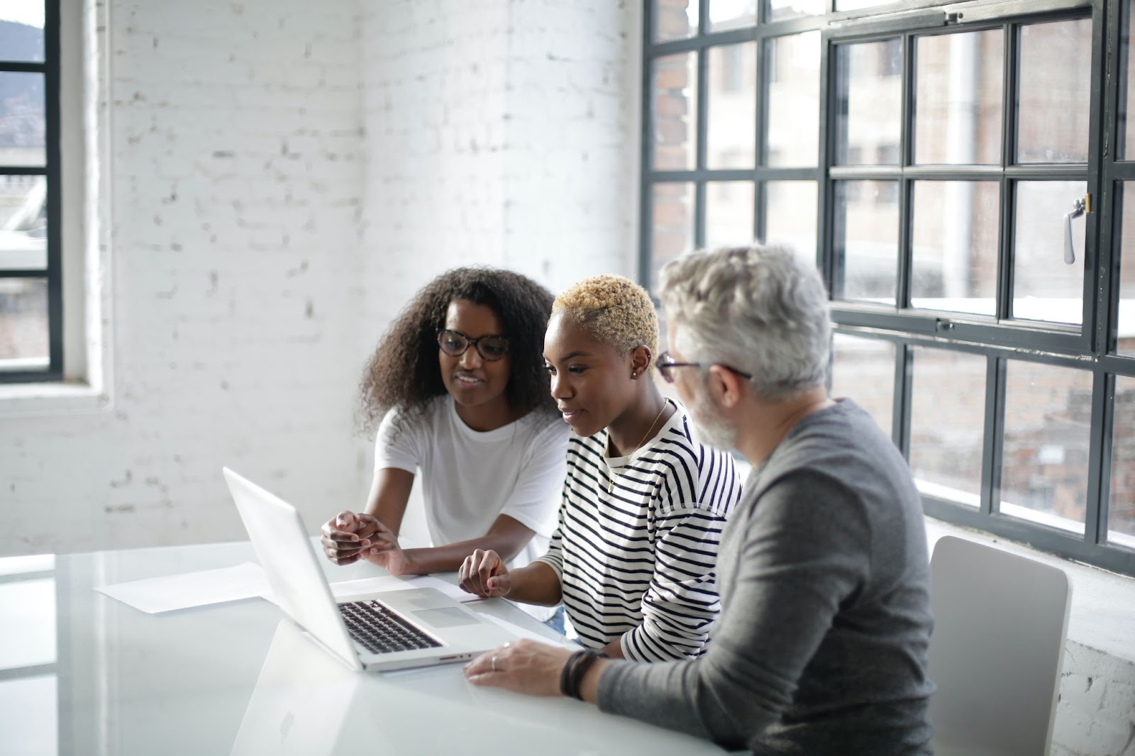 A photo of three professionals working together in a casual office environment.