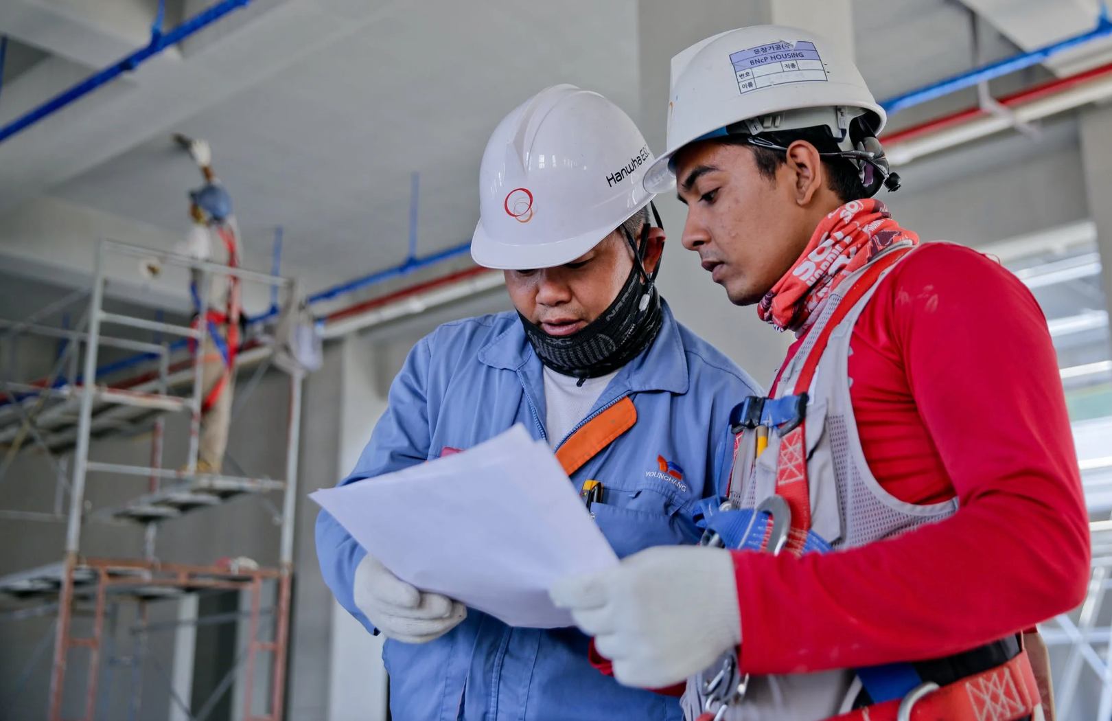 Photo of two construction workers looking at documentation together