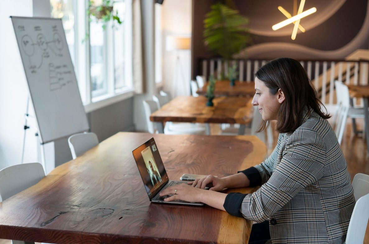 Photo of a young professional sitting at a table and calmly working on a laptop