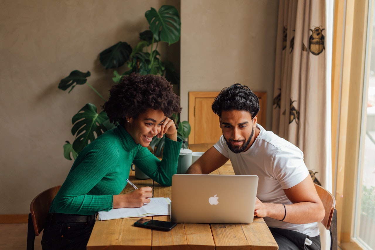 Photo of two colleagues looking at a laptop’s screen together