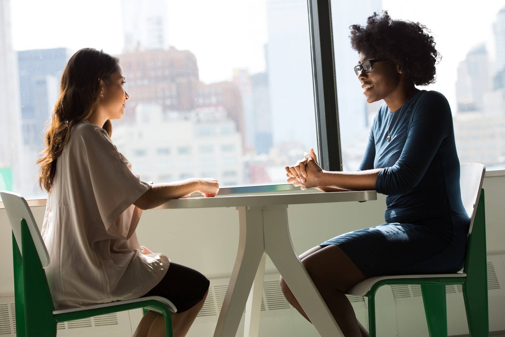 A photo of two professionals having a conversation at a table.