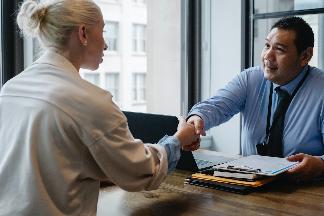 Photo of two employees shaking hands in agreement.