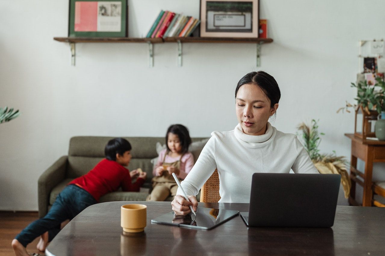 Photo of a professional working from home with kids in the background.