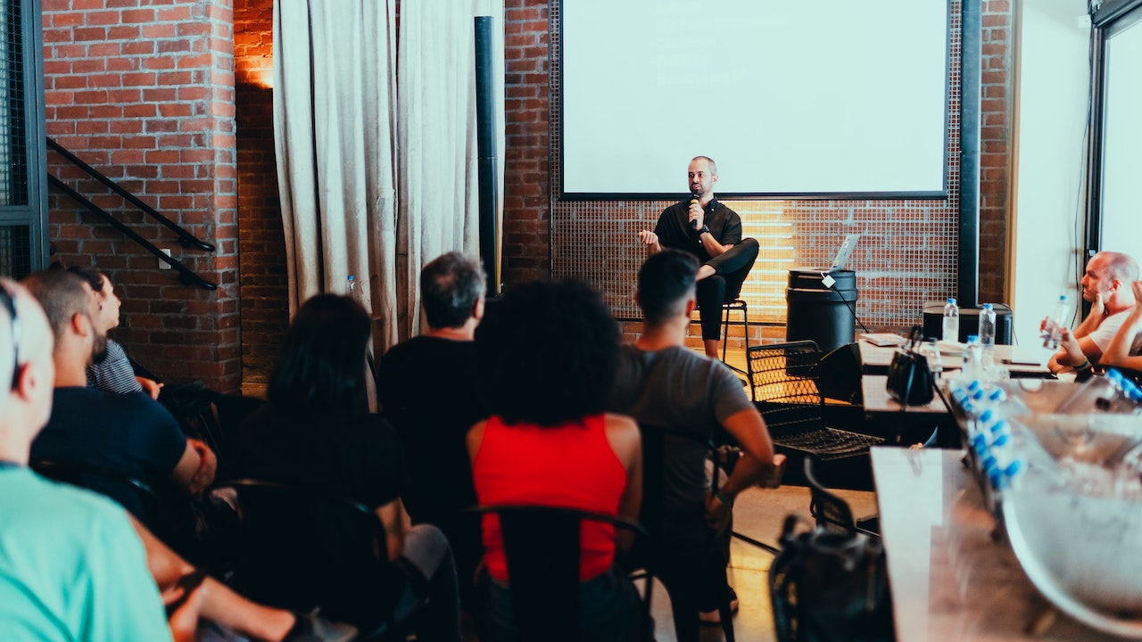 A photo of a professional giving a talk to a room full of people.