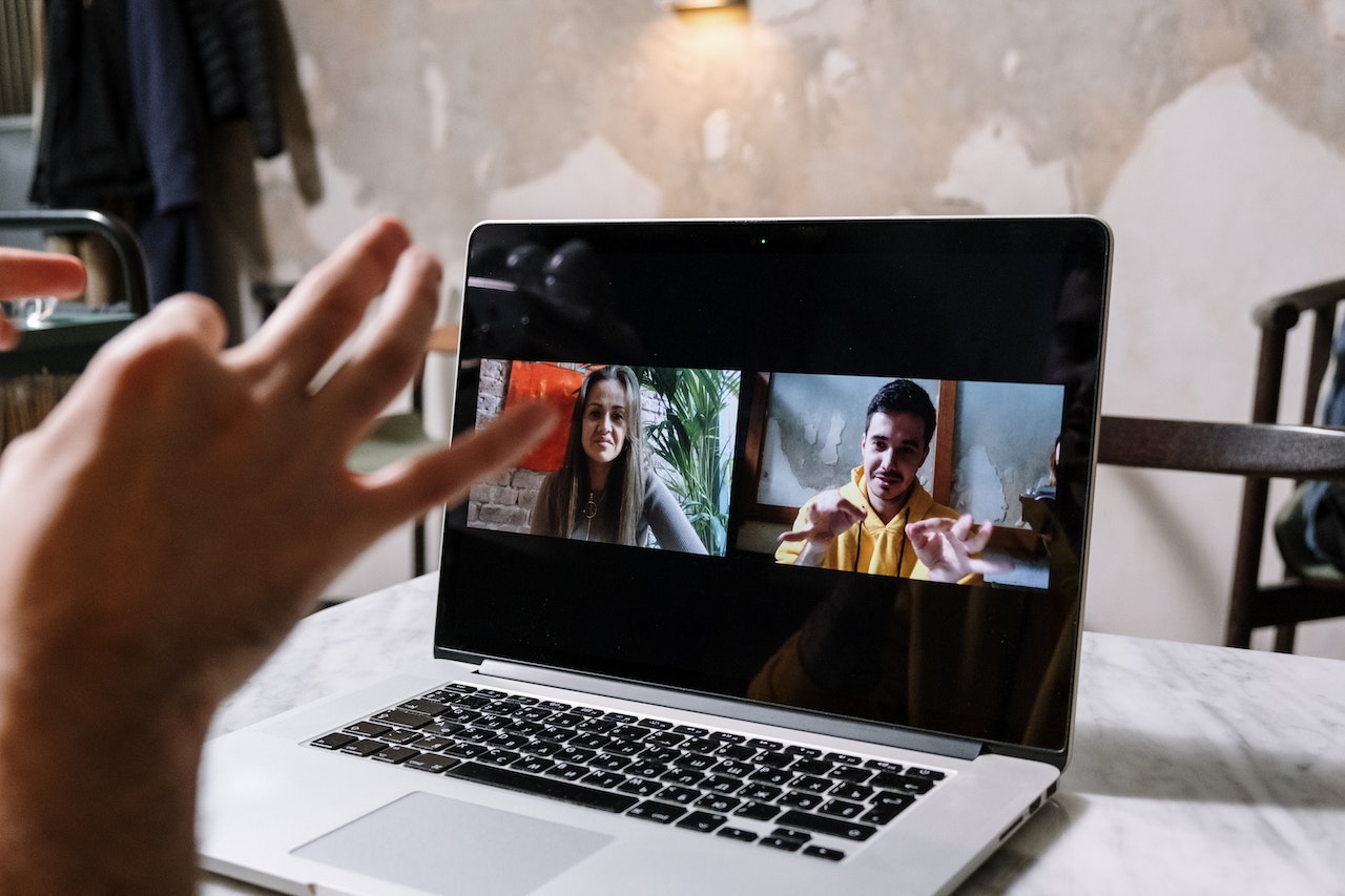 Photo of a professional having an online meeting with two of their colleagues.