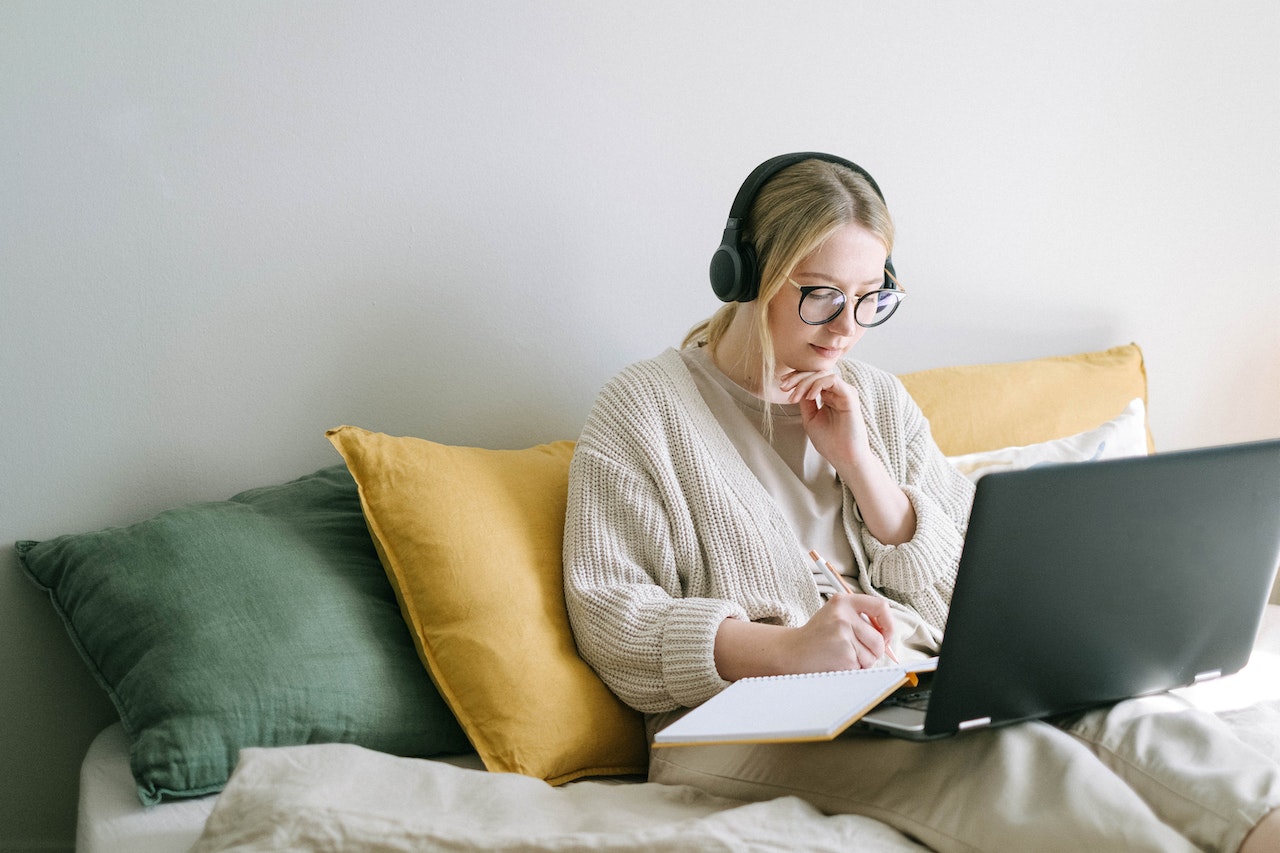 A photo of a remote worker learning from a comfortable space in their home.