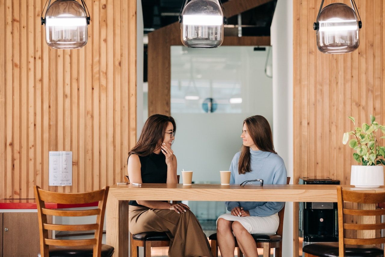 Photo of two professionals having a coffee and socializing in the break room.