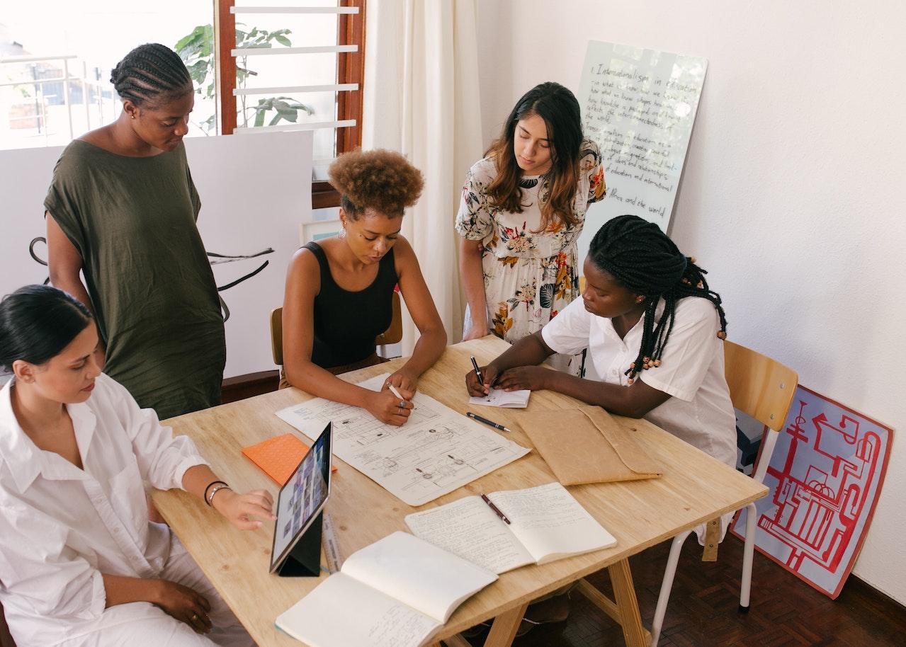 Photo of a group of professionals in a meeting to discuss goals and objectives.