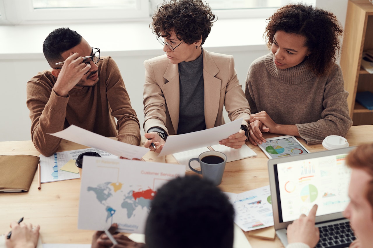 A photo of a group of colleagues collaborating together at a large table.