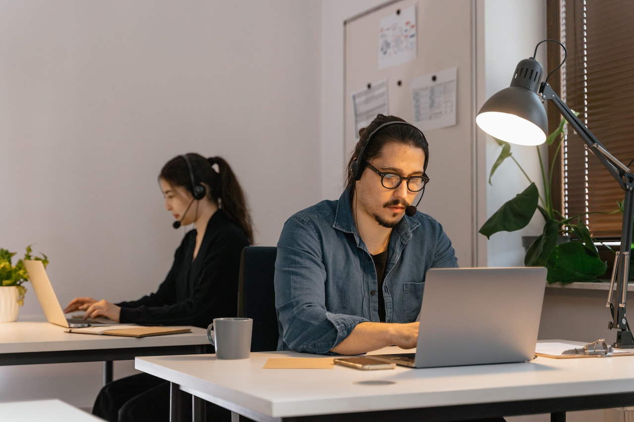 A photo of two professionals working quietly at individual desks.