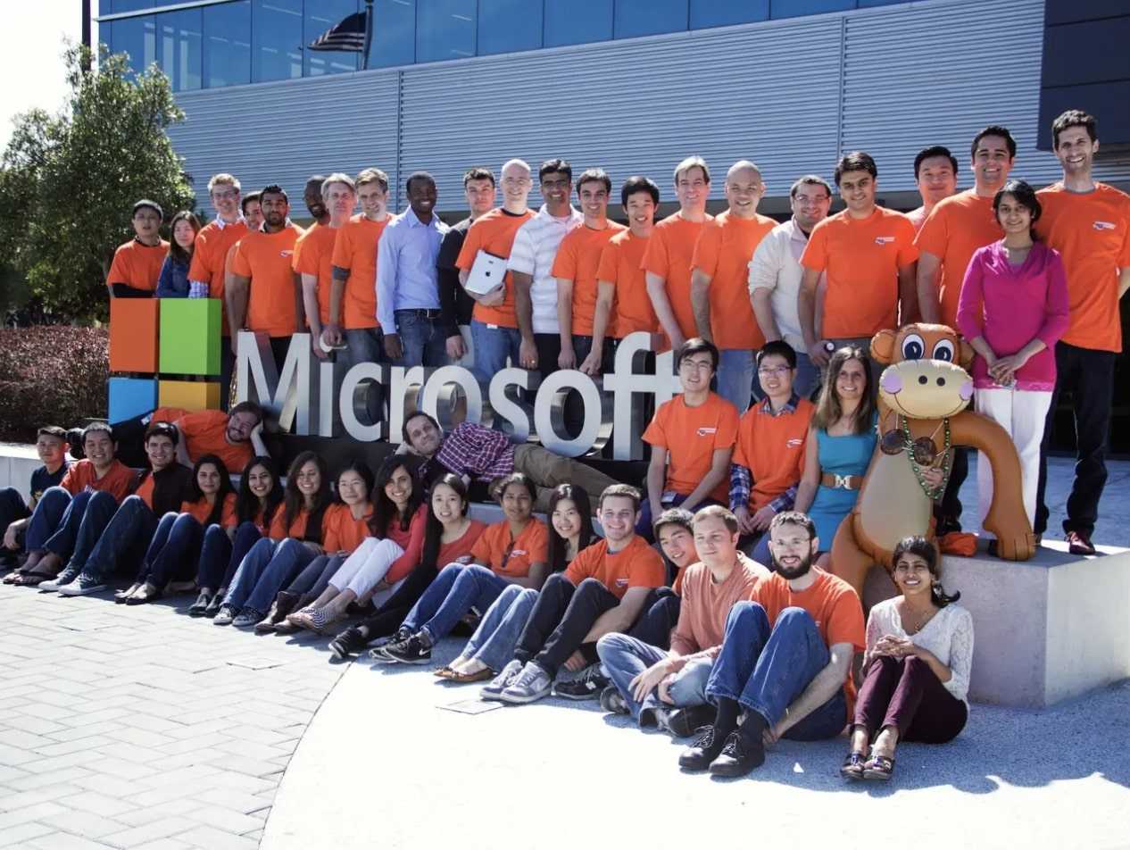 A photo of Microsoft employees posing in front of the company's offices.