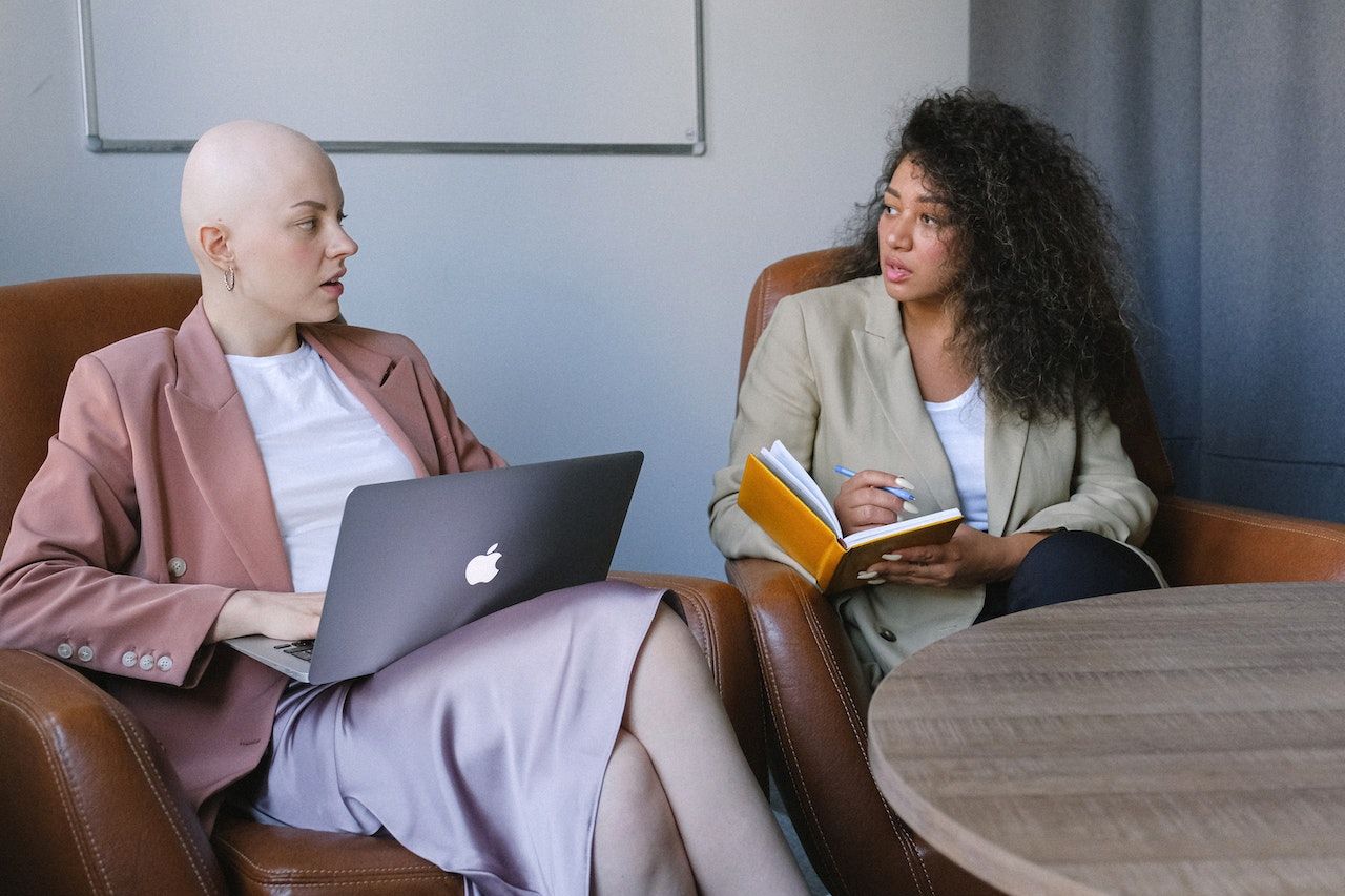 A photo of two employees in a private meeting.