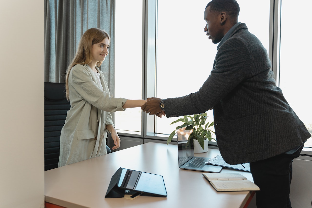 A photo of a manager shaking hands with a candidate during an interview.