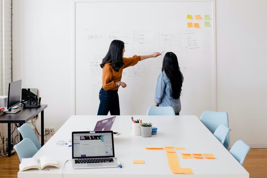 Image depicting employees gathered in a boardroom strategizing and problem solving. 